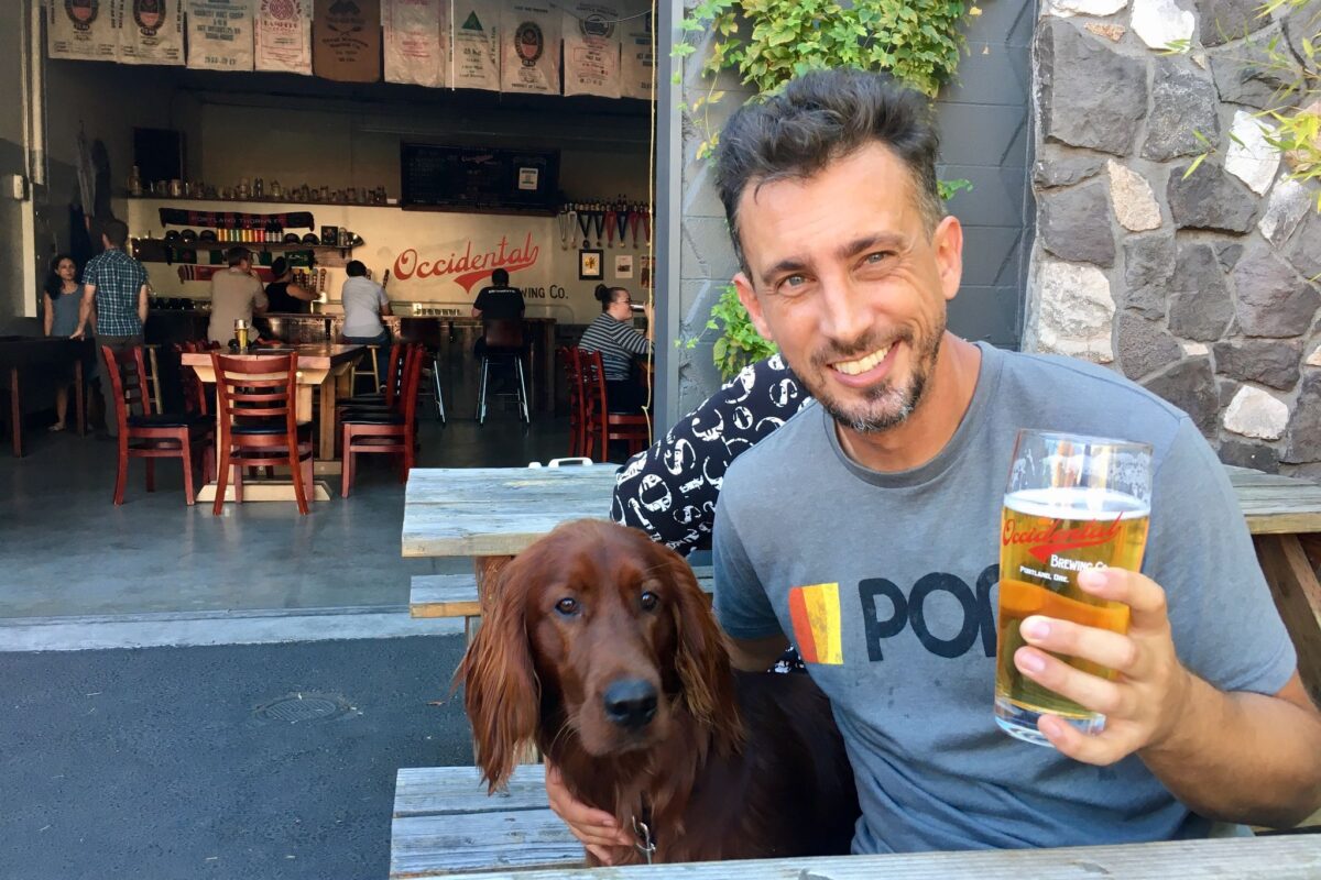 Cofounder of Cinemaloop - Henry with a beer in his hand, sitting with his Irish Setter Rusty, outside of a eating establishment in Los Angeles.
